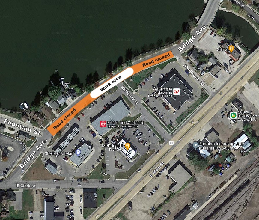 Aerial map view showing a road closure and work area on Bridge Ave near businesses including McDonald's, Walgreens, and China Buffet, next to a river.