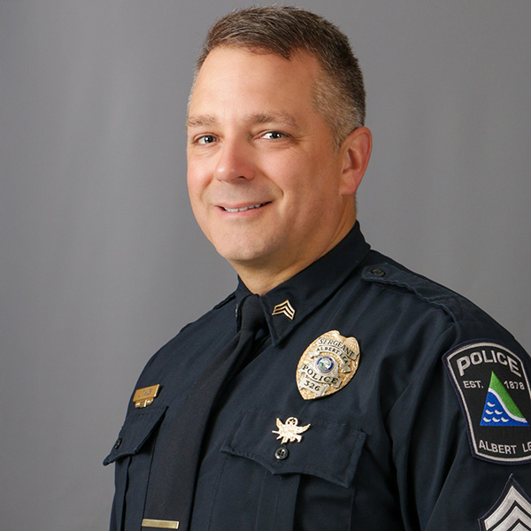 Jason Taylor, A uniformed police officer smiling against a gray background.