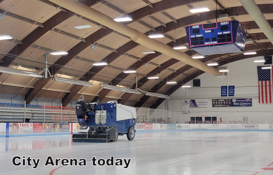 An ice resurfacing machine cleans the rink at an empty indoor arena; scoreboard and American flag are visible overhead. Text reads 