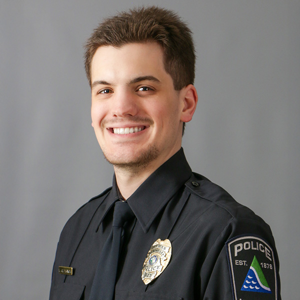 Keith Gryzbowski, A police officer in uniform with badges, standing in front of a neutral background, smiling.