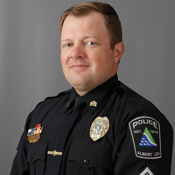 Stephen Charboneau, A police officer in uniform poses against a neutral background, featuring badges and insignia on the uniform.
