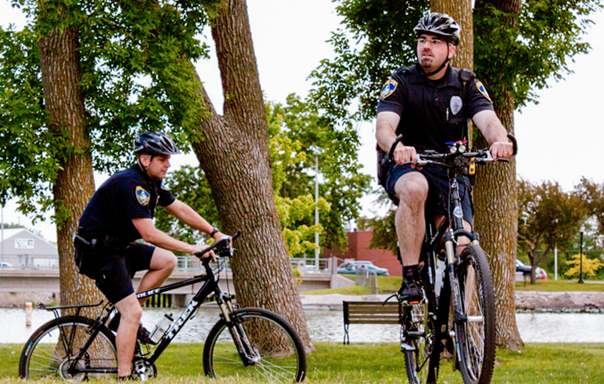 Two police officers on bicycles wearing bike helmets