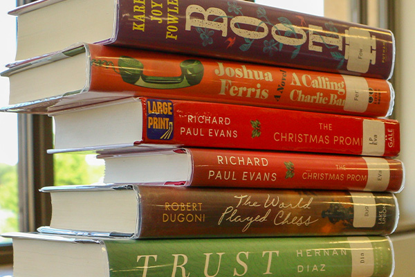 A stack of six hardcover books, including titles like 