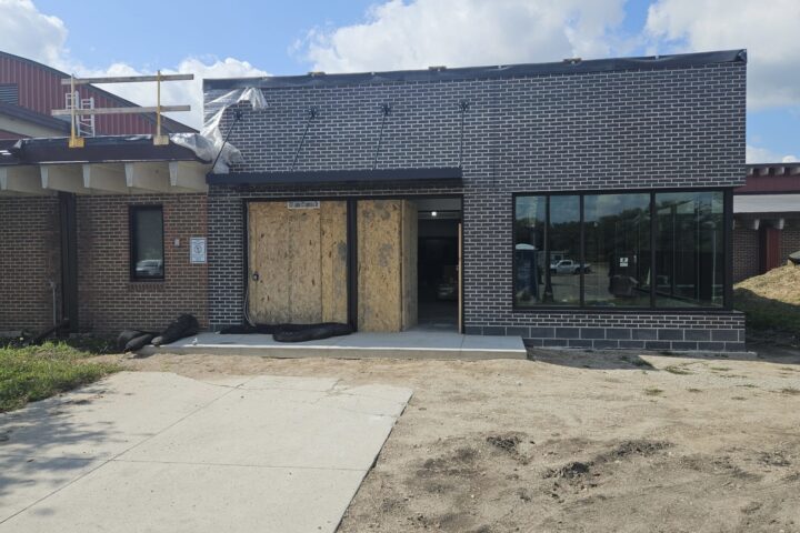 front of a brick building with front doors boarded up