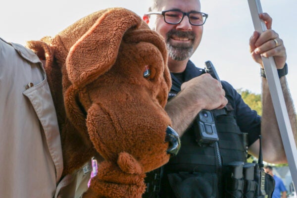 a police officer stands with a person in a dog costume dressed as McGruff the crime dog